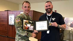 Image of two men holding onto an award. Click to open a larger version of the image.