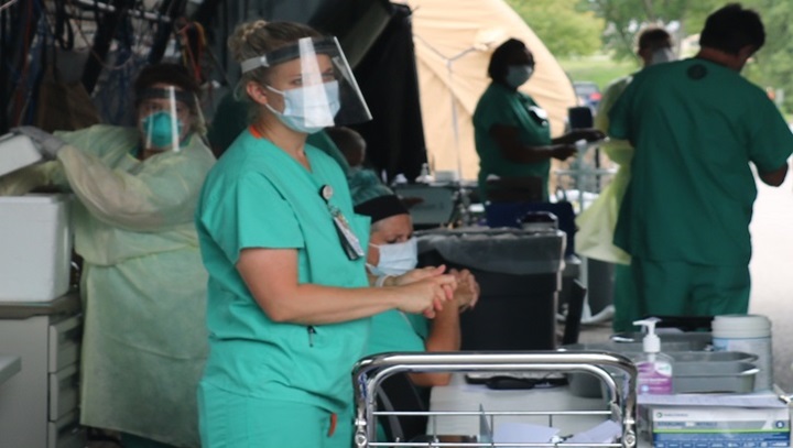 Image of Medical personnel set up in an outside military tent.