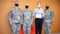 Military personnel wearing face masks posing for a picture