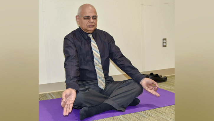 Dr. Bhagwan Bahroo, staff psychiatrist, demonstrates a deep-breathing posture as he leads a weekly yoga class for Psychiatry Continuity Service Program participants at Walter Reed National Military Medical Center. (DoD photo by Leigh Culbert)