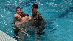 U.S. Army Staff Sgt. Dominic Kochen and U.S. Army 2nd Lt. Aiden Fox attempt to complete a water rescue during the Brooke Army Medical Center Best Medic and Best Squad competition at the Jimmy Brought Fitness Center