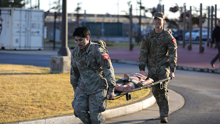 U.S. Army Sgt. Anthony Castro, a combat medic specialist assigned to 121st Field Hospital, and U.S. Army Staff Sgt. Jeoung Ho Park, a combat medic specialist assigned to 75th Medical Company Area Support, carry a simulated casualty at the 2023 Eighth Army Best Medic Competition at U.S. Army Garison Humphreys, South Korea, on Nov. 17, 2023. (Photo by U.S. Army Spc. Diego Figueroa/20th Public Affairs Detachment)