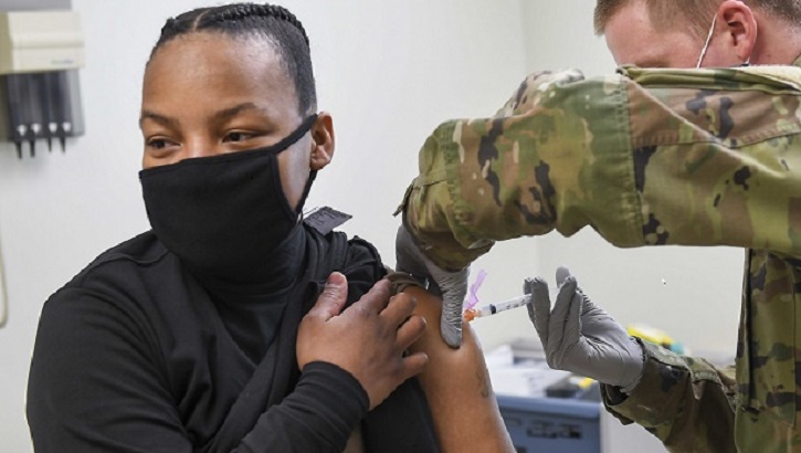 Image of military personnel wearing a face mask receiving the COVID-19 vaccine. Click to open a larger version of the image.