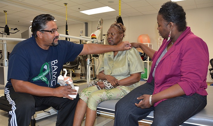Leville Crowther (left), physical therapy assistant, explains shoulder mechanics to Kathryn Harris (center) and her daughter, Robbie Harris. 