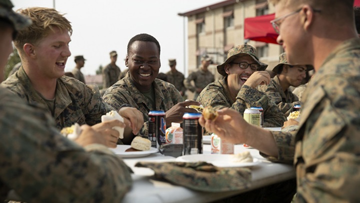 Image of Picture of military personnel sitting at a table eating food together.