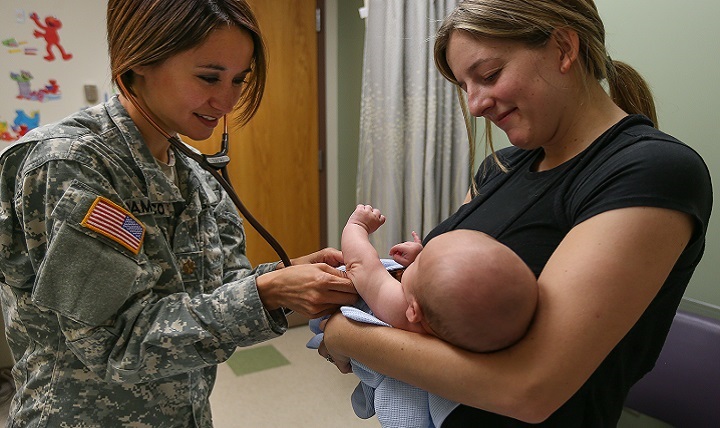 Maj. Veronica Damasco, a physician at Madigan Army Medical Center, Washington, checks out Parker McPherson with his mother, Brea.