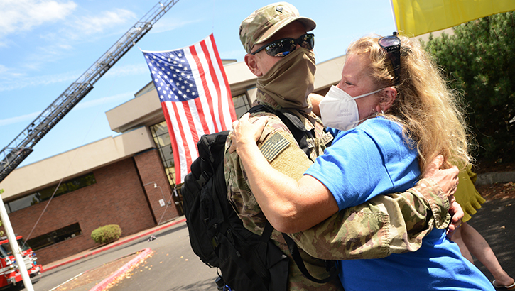 Image of Military husband hugging his wife. Click to open a larger version of the image.