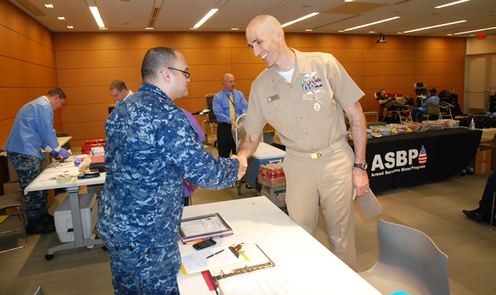 Navy Master Chief Petty Officer Terry Prince (right), Defense Health Agency senior enlisted adviser, talks with a fellow sailor during a blood drive at the agency's headquarters in Falls Church, Virginia. 