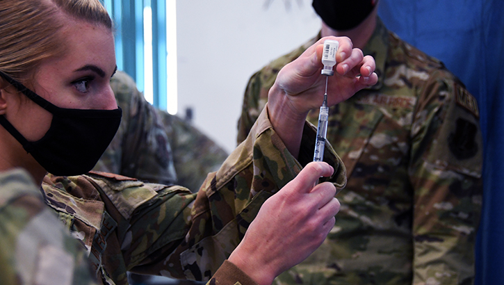 Military personnel administering the COVID-19 vaccine