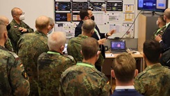 Officers watch a presentation in a room.