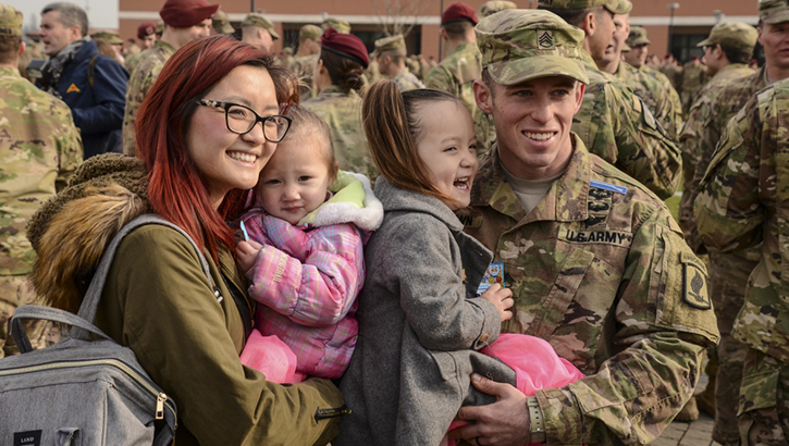 Image of Military family posing for a picture. Click to open a larger version of the image.