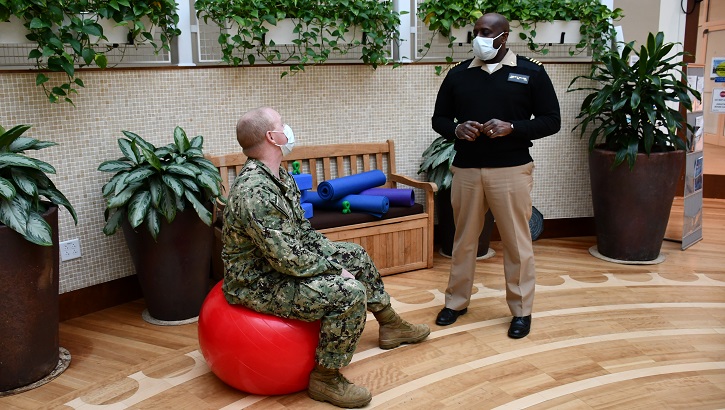 Image of Military personnel wearing face mask while talking to each other.
