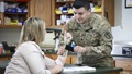 A soldier fits a custom brace for a carpal tunnel patient’s wrist. 