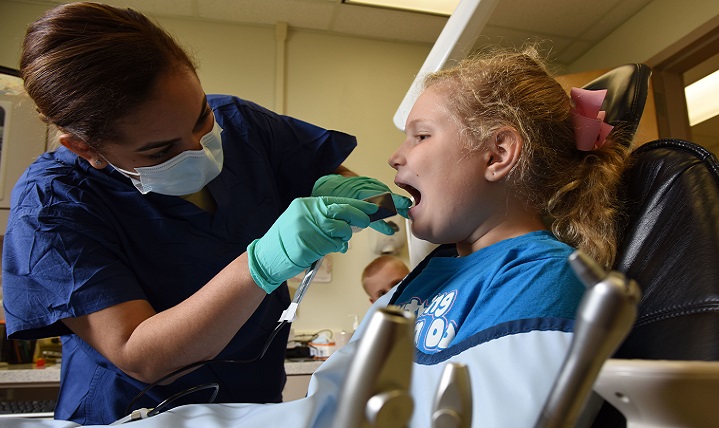 Air Force Senior Airman Caitlyn Hollowell, 81st Dental Squadron dental technician, prepares to take an x-ray on Katelyn Landolt. February is Children’s Dental Health Month. (U.S. Air Force photo by Kemberly Groue)