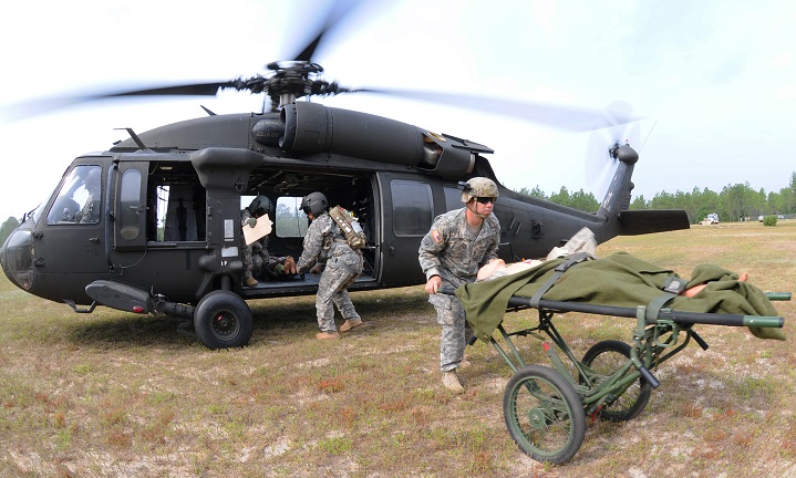 Sergeant 1st Class Deane Bostick, U.S. Army School of Aviation Medicine, Academic Operations NCO in charge, rushes a simulated patient off of a UH-60 Black Hawk during a training exercise meant to test student flight medics' abilities to provide care in an operating aircraft. 