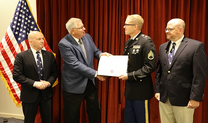 Uniformed Services University of the Health Sciences President, Dr. Richard Thomas (left) and USU College of Allied Health Sciences Dean Dr. Mitchell Seal (right) watch as the former university Senior Vice President Dr. Patrick Sculley presents Army Staff Sgt. Robert Eccles with an Associate of Science degree in Health Sciences.  Eccles is the first CAHS degree recipient.  (DoD photo by Sharon Holland)
