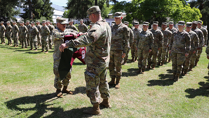 U.S. Army Col. Enrique Luna, (left) commander of the 7450th Medical Operational Readiness Unit Det 64 cases the unit colors during a transfer of authority ceremony at Landstuhl Regional Medical Center on July 8, 2024. (Photo by Kirk Frady/Medical Readiness Command, Europe)