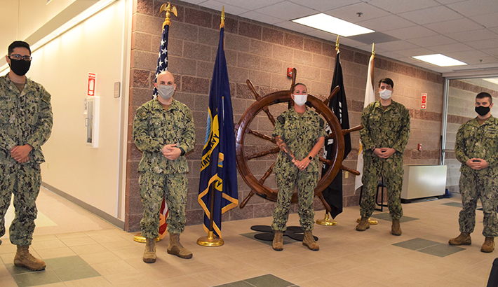Five military personnel standing, in masks