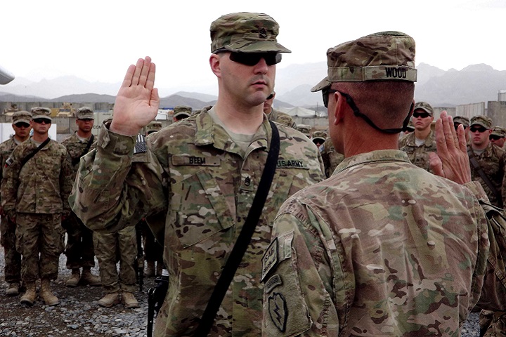 Army Col. Todd R. Wood, commander of the 1st Stryker Brigade Combat Team, 25th Infantry Division, administers the oath of re-enlistment to Army Staff Sgt. Brian Beem, left, then a cavalry scout assigned to the 5th Squadron, 1st Cavalry Regiment, at Forward Operating Base Frontenac, Afghanistan, Nov. 9, 2011. Beem is a single-leg amputee who was able to continue to serve despite his injury. He lost his leg after an improvised explosive device detonated during his 2006 deployment to Iraq. (U.S. Army photo by Sgt. Thomas Duval)