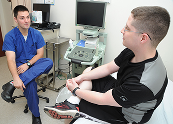 Military personnel discuss treatment plan at urology clinic