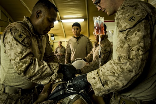 Navy Petty Officer 1st Class Cesar Borrero, left, an x-ray technician, and Seaman Andrew Ott, a field medical technician, fasten a pelvic stabilization device to an essential care simulator manikin during shock trauma section drills. (U.S. Marine Corps photo by Sgt. Justin Huffty)