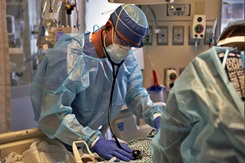 Air Force 1st Lt. Anthony Albina, a critical care nurse assigned to Joint Base Andrews, Md., checks a patient’s breathing and heart rate during an intubation procedure while supporting COVID-19 response operations in Cleveland, Jan. 20, 2022.