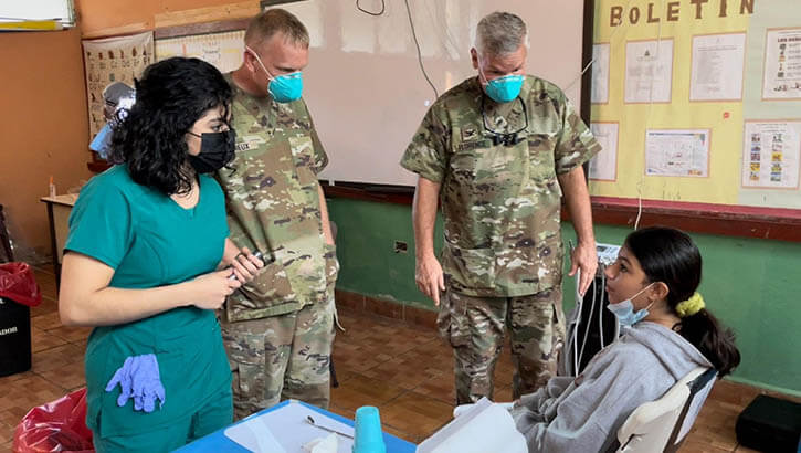 Image of U.S. Army Sgt. Thomas Lemieux (center), dental assistant with Army Forces Battalion, Joint Task Force-Bravo, and Col. Franklin Florence (right), general dentist with Army Forces Battalion, Joint Task Force-Bravo, prepare a patient for an extraction with assistance from a Honduran volunteer during a Global Health Engagement at Los Laureles, Santa Barbara department, Honduras, Feb. 15. JTF-Bravo, in conjunction with Honduran Ministry of Health representatives, conducted the mission to provide dental and other medical services with volunteer support from Honduran medical students, who served as interpreters.