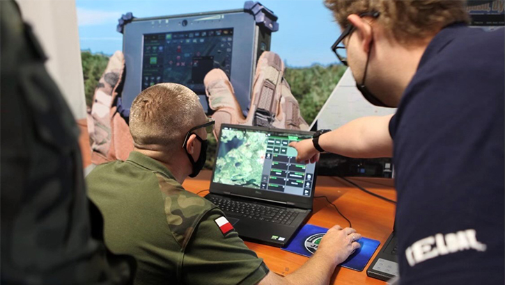 Military personnel looking at a laptop screen