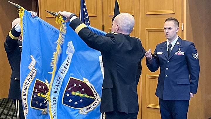 Image of Two men unfold flags.