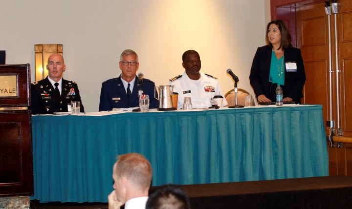 Tricia Cantu (standing), chief of the Defense Health Agency’s Health IT Investment Branch, discussed standardizing health IT processes to improve efficiency and save money. 