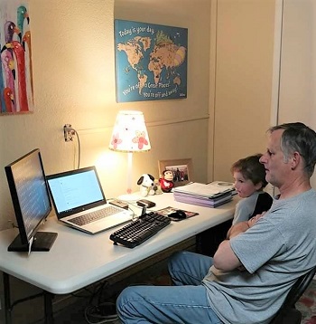 Image of man sitting at desk with son on his lap