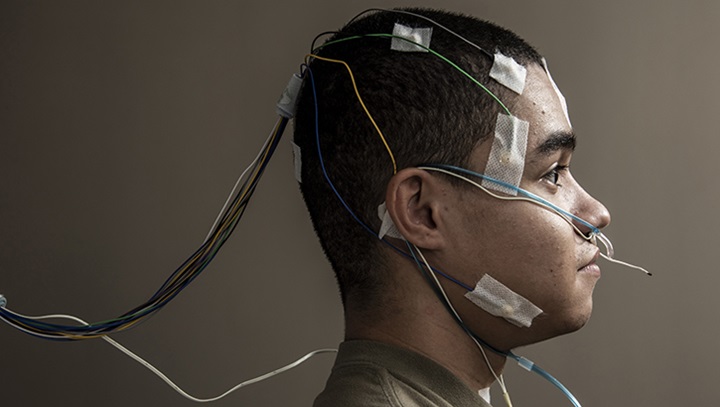 Image of Airman with elecronic trackers on his head seen in profile for a sleep disorder study on TSD.
