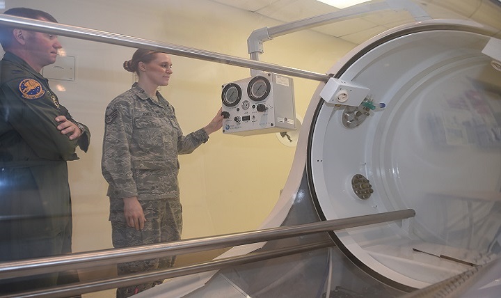 Air Force Col. Michael Richards, 59th Hyperbaric Medicine Flight commander, observes as Air Force Staff Sgt. Sherri Jones, hyperbaric medical technician, demonstrates the controls of the monoplace hyperbaric chamber at the Wilford Hall Ambulatory Surgical Center, Joint Base San Antonio-Lackland.