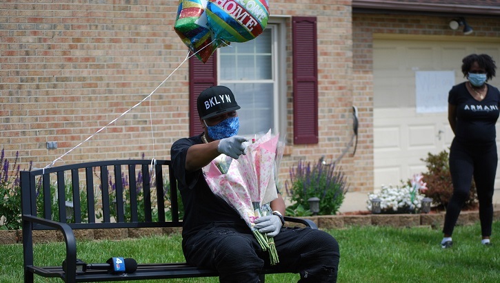 Image of soldier sitting on a bench with flowers and a balloon
