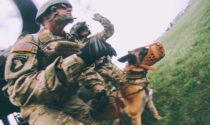Army Staff Sgt. Erik Rosengren (left) and Military Working Dog, Hella, prepare to board a helicopter during MEDEVAC training for MWD teams. 