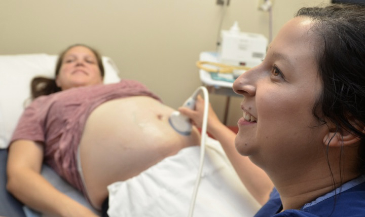 Navy Lt. Jessica Miller, a certified nurse midwife in Naval Hospital Jacksonville’s pregnancy Integrated Practice Unit, assesses a patient. (U.S. Navy photo by Jacob Sippel)