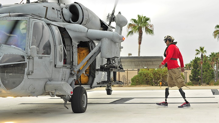 Image of A man walks toward a helicopter.