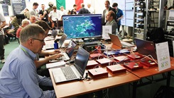 Men and women in room sitting in front of their laptops