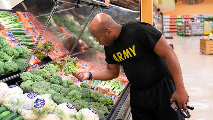 Image of Military personnel picking out broccoli.