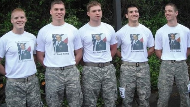 Image of Five young men standing in a line, wearing the same t-shirt and pants.
