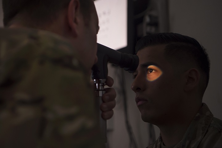 Air Force Lt. Col. Peter Carra, 379th Expeditionary Medical Group optometry officer in charge, performs an eye exam for a Soldier at Camp As Sayliyah, Qatar. (U.S. Air Force photo by Tech. Sgt. Christopher Hubenthal)