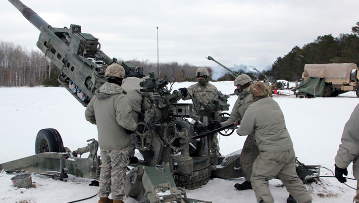 Military personnel standing in the snow preparing to fire a missile 