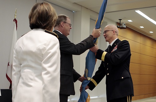 Assistant Secretary of Defense for Health Affairs Tom McCaffery (center), passes the colors to the new DHA director, Army Lt. Gen. Ronald Place (right), as Navy Vice Adm. Raquel Bono, the outgoing director of the Defense Health Agency, watches. (MHS photo)
