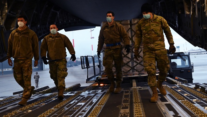Picture of military personnel wearing face masks walking into an aircraft 