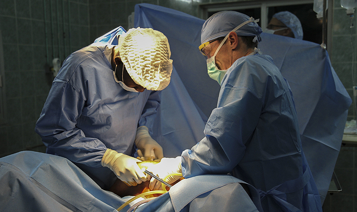 Dr. Mansour Niang (left), a Senegalese gynecologist, and Dr. Anthony Donaldson, a major in the Vermont Air National Guard, perform surgery during a joint medical readiness training exercise at a hospital in Dakar, Senegal. (U.S. Army photo by Maj. Simon Flake)