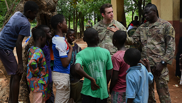 Military medical personnel with local children in Ghana