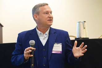 Link to Photo: Mark Goodge, chief technology officer for the Defense Health Agency, speaks to attendees of the Defense Health Information Technology Symposium about the agency Desktop to Datacenter initiative.