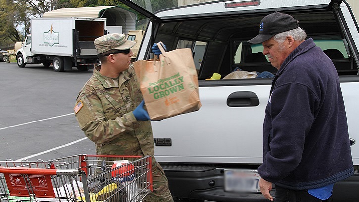 Army Sgt. Moises Castillo of the California Army National Guard helps an Amador County resident load food supplies into a vehicle at the Interfaith Food Bank in Jackson, Calif., March 23, 2020. (U.S. Army photo illustration by Army National Guard Staff Sgt. Eddie Siguenza)