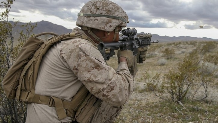 Marine holding and aiming a rifle
