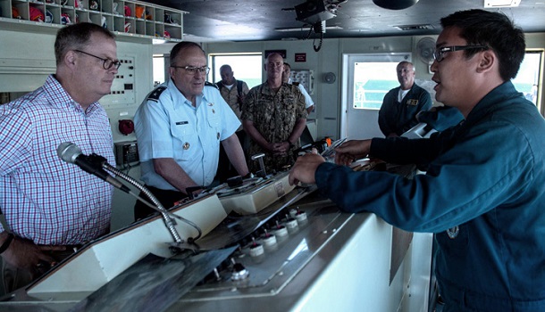 U.S. Military Sealift Command Cmdr. Andrew Chen, chief mate aboard the hospital ship USNS Comfort, (right), gives U.S. Air Force Maj. Gen. Lee E. Payne, (center), assistant director for Combat Support, Defense Health Agency, and Tom McCaffery, assistant secretary of Defense for Health Affairs, a tour of the ship while off the coast of Port-Au-Prince, Haiti. Comfort is working with health and government partners in Central America, South America, and the Caribbean to provide care on the ship and at land-based medical sites, helping to relieve pressure on national medical systems, including those strained by an increase in cross-border migrants. (U.S. Navy photo by Mass Communication Specialist Seaman Jordan R. Bair)
